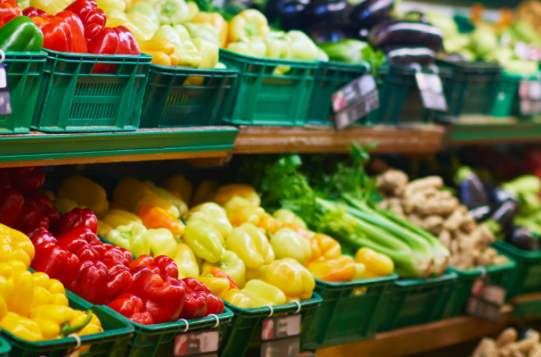 A long supermarket shelf with colourful fresh fruit and vegetables