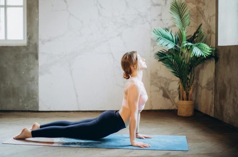 A woman performing a yoga pose on a yoga mat