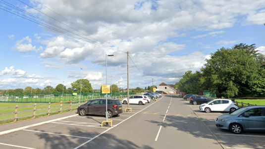 Cars parked in the car park alongside the green space at Cantley Park in Wokingham