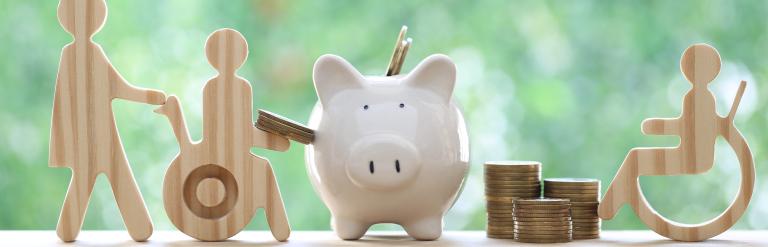 Wooden figure putting money in a piggy bank